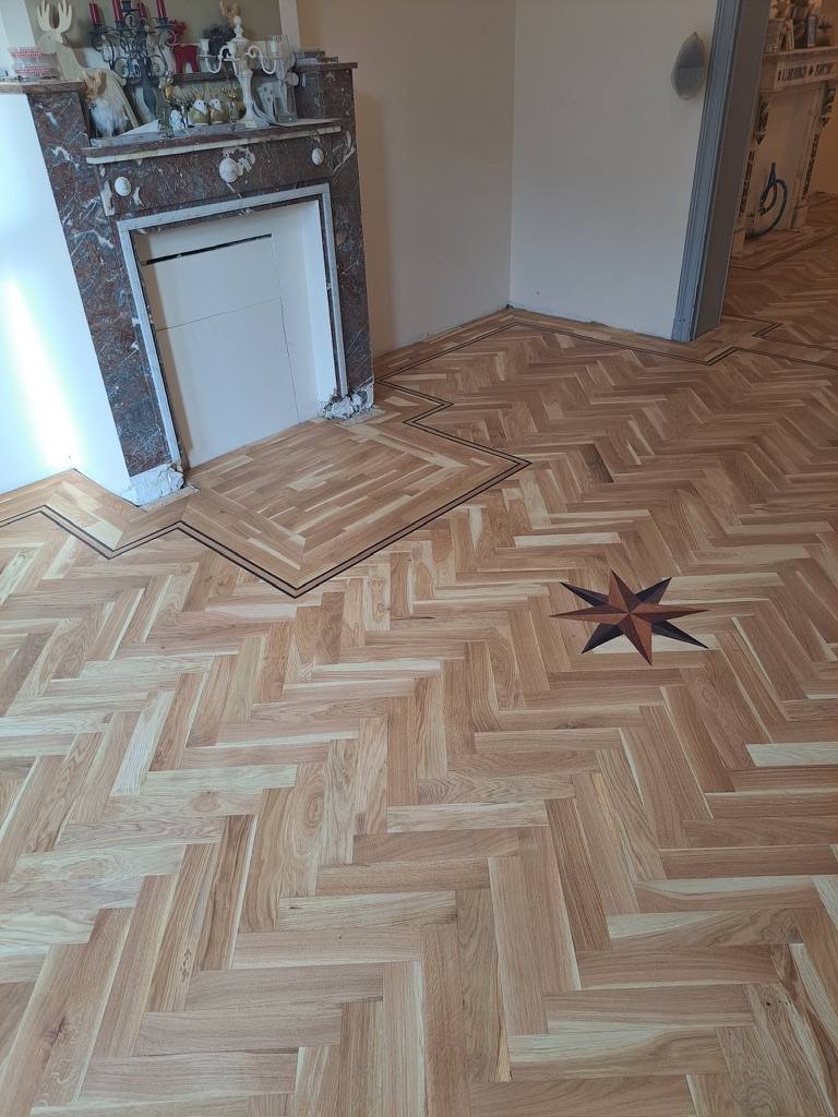 Oak herringbone parquet with marquetry star inlay and decorative border
