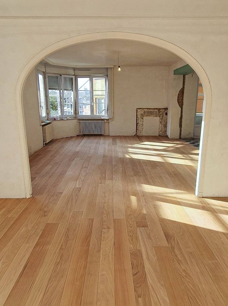 Solid oak plank floor in a renovated apartment with arch