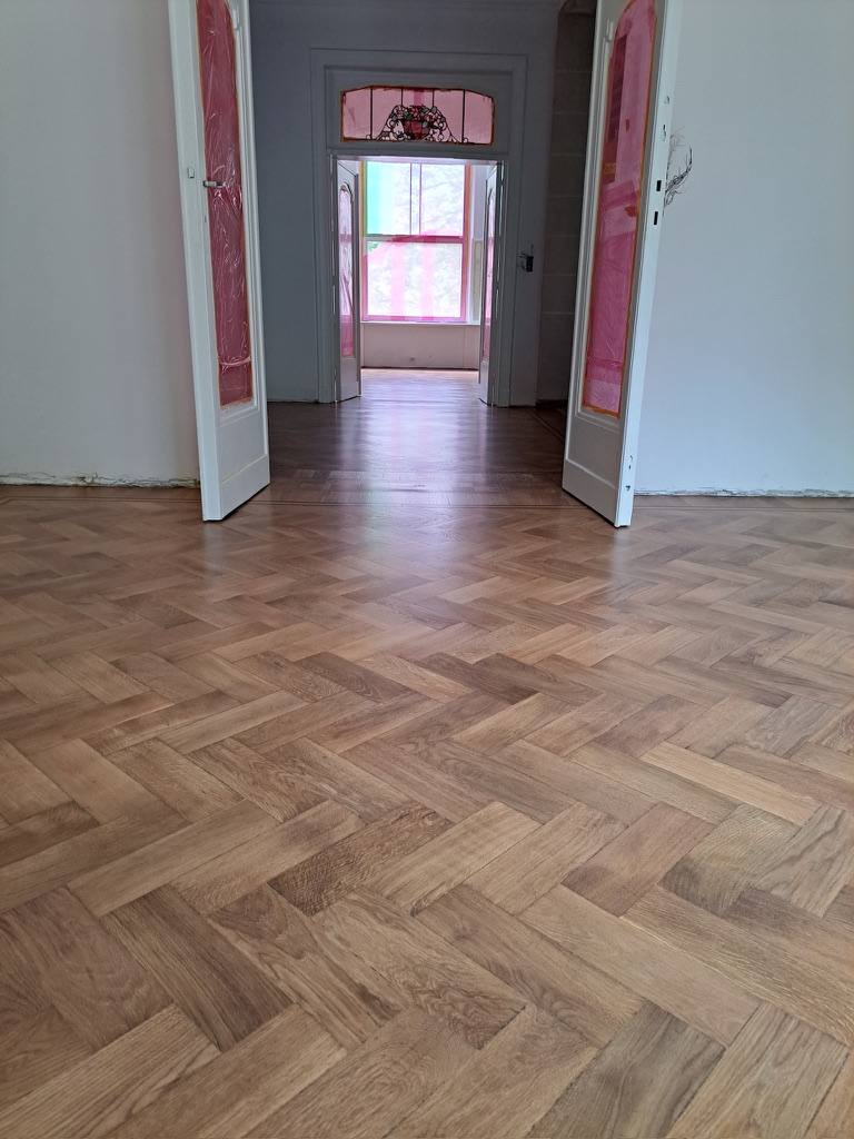 Herringbone parquet running through double doors into adjoining rooms