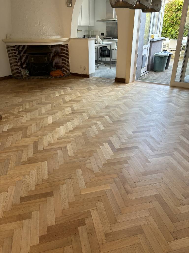 Restored herringbone parquet floor near fireplace